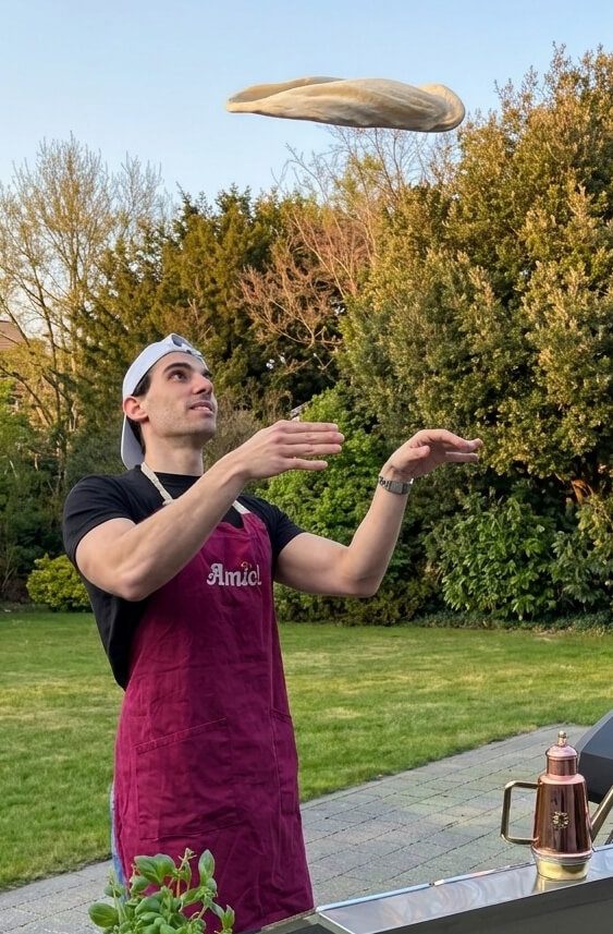 Diego van Amici bereidt een ambachtelijke pizza, ideaal voor pizza- en pastacatering en authentieke Italiaanse foodbeleving.