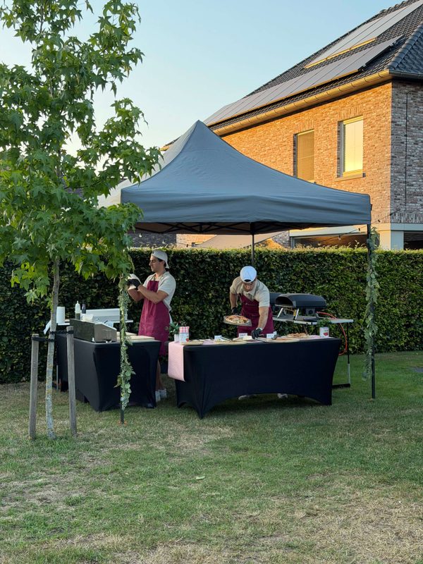 Professionele catering op locatie met Amici pizzabakkers en een mobiele pizza-oven tijdens een gezellig tuinfeest.