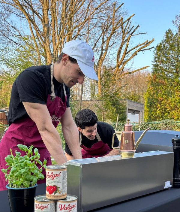 Amici-chefs Diego en Davide aan het werk bij hun pizza en pasta catering op locatie.