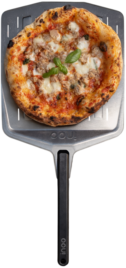 Vers gebakken pizza met tonijn, mozzarella en basilicum op een metalen pizzaschep.