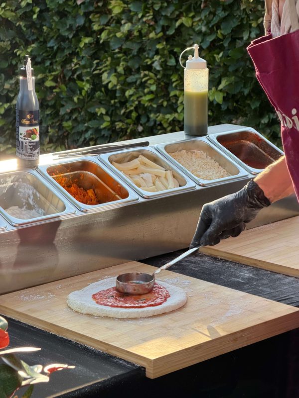 Amici-chef aan het werk bij hun pizza en pasta catering op locatie.